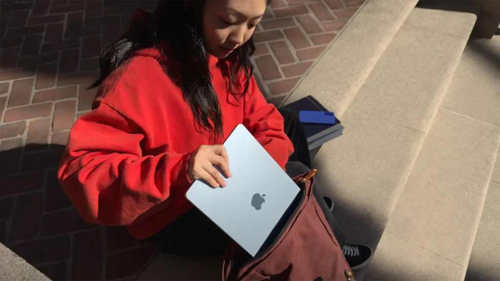 A student putting her mac book in her bag
