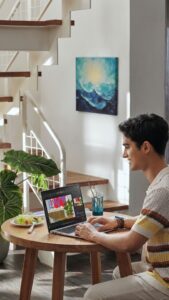 A young man using the Acer Swift Go 14 OLED laptop at a wooden table in a bright, modern room. The screen shows a photo editing application, highlighting the Intel AI PC capabilities and sleek design.