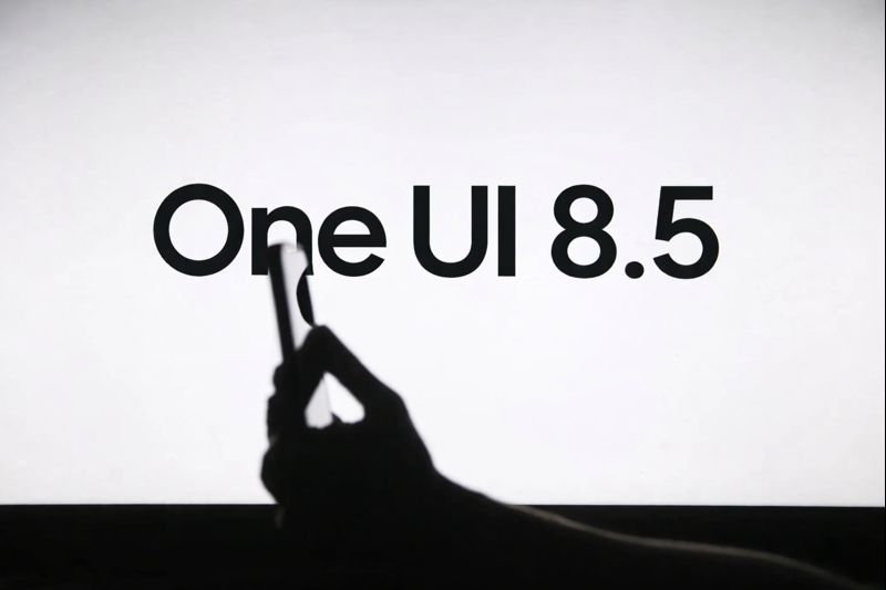 Minimal black and white graphic showing ‘One UI 8.5’ text with a hand holding a Samsung smartphone