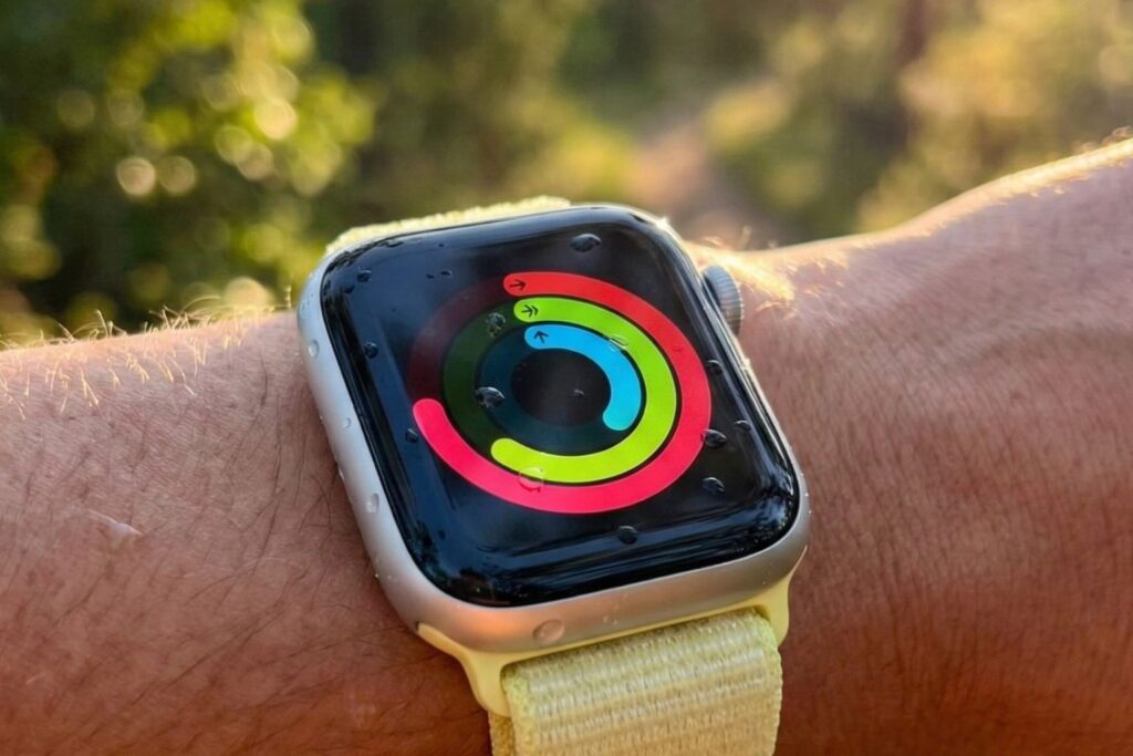 Apple Watch on wrist displaying Activity rings outdoors in natural sunlight