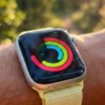 Apple Watch on wrist displaying Activity rings outdoors in natural sunlight