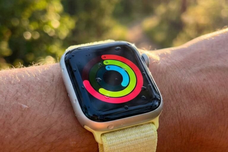 Apple Watch on wrist displaying Activity rings outdoors in natural sunlight