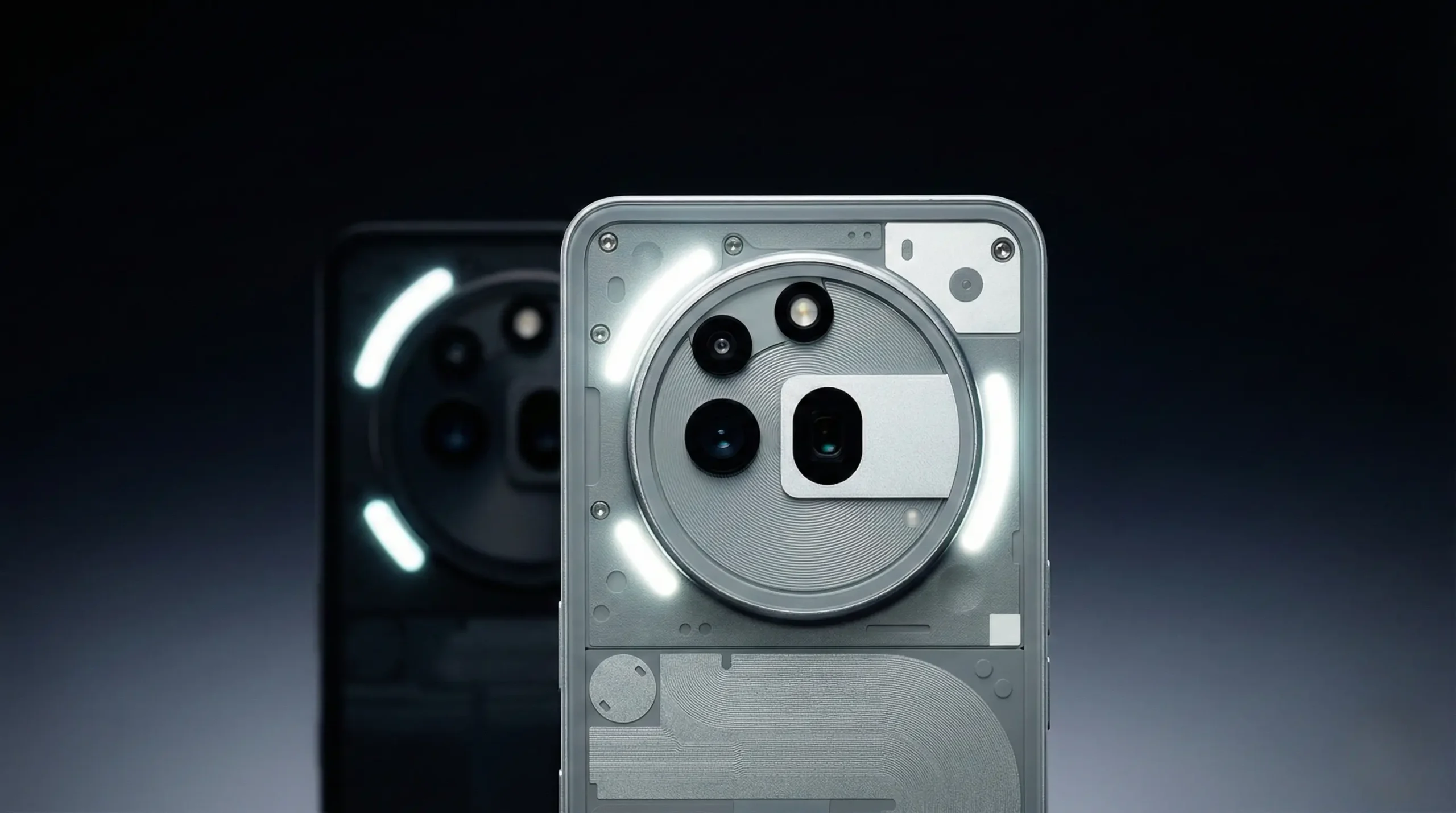 White Nothing Phone 4a shown from the rear, centered against a dark gradient background. The image focuses on the large circular camera module with multiple lenses and a rectangular sensor cutout, surrounded by illuminated white Glyph LED strips. A black variant appears softly blurred in the background.