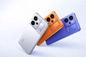 Realme P4 Power 5G shown in silver, orange, and blue color options with rear camera design on a light background.