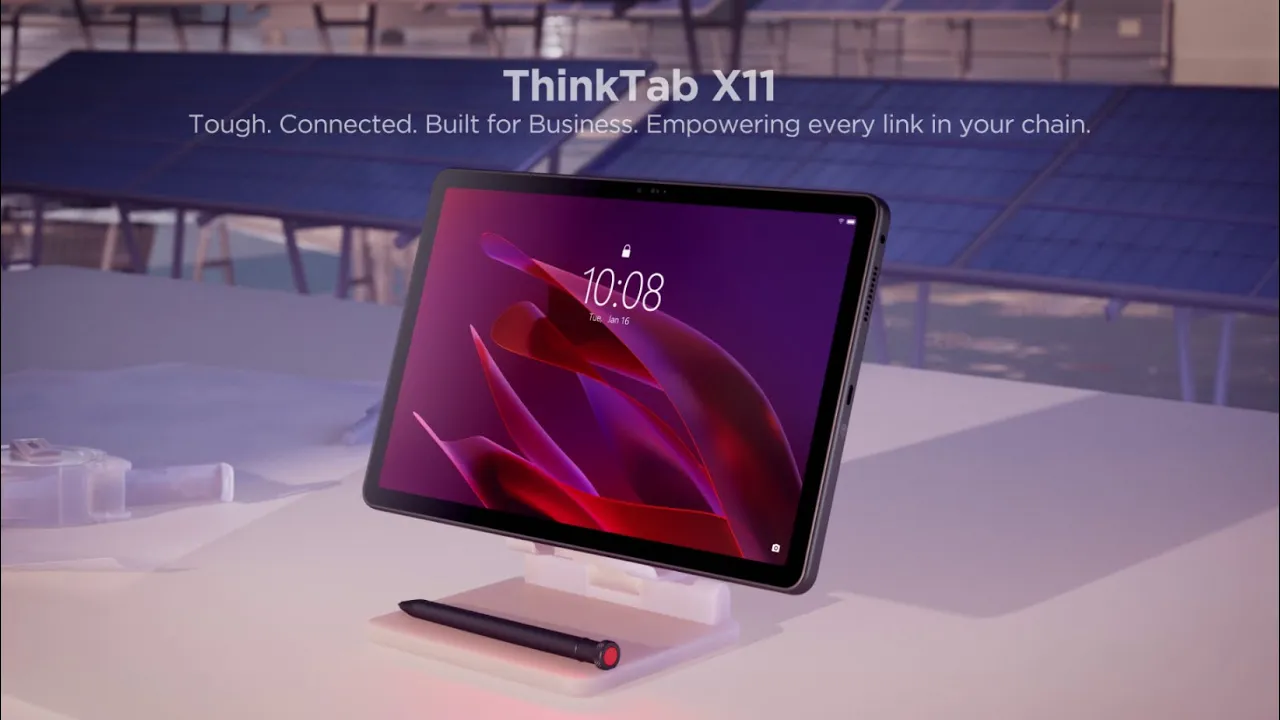 Lenovo ThinkTab X11 rugged tablet on a desk stand with a stylus, set against a backdrop of solar panels.